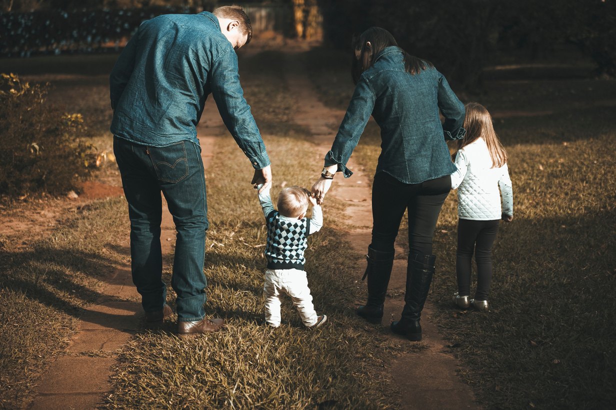 Famille tenant un jeune enfant par la main